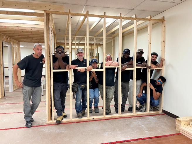 North American Trade School crew posing in the new wall framing during the London Scottish Rite Learning Centre expansion